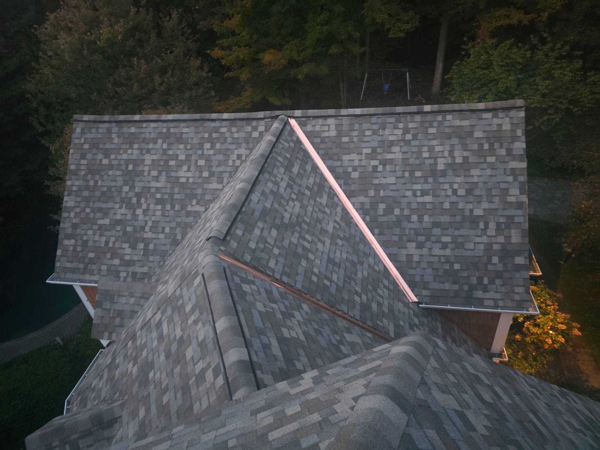 Copper valleys carrying water between shingle roof planes